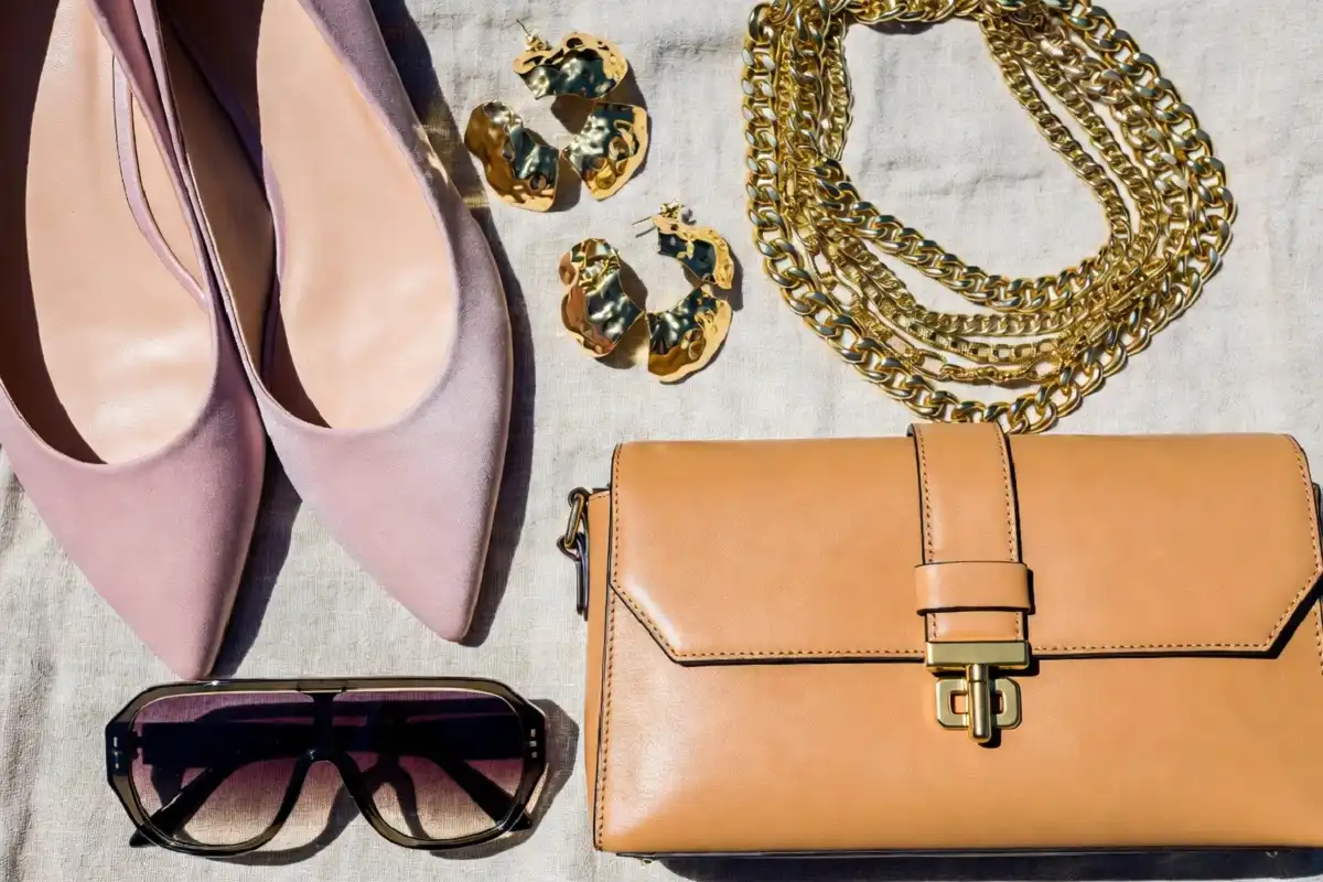 Stylish 2024 fashion accessories including ballet flats, a baguette bag, and layered gold necklaces