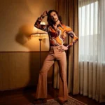 Man in 70s fashion men style with wide collar shirt flared trousers and platform shoes