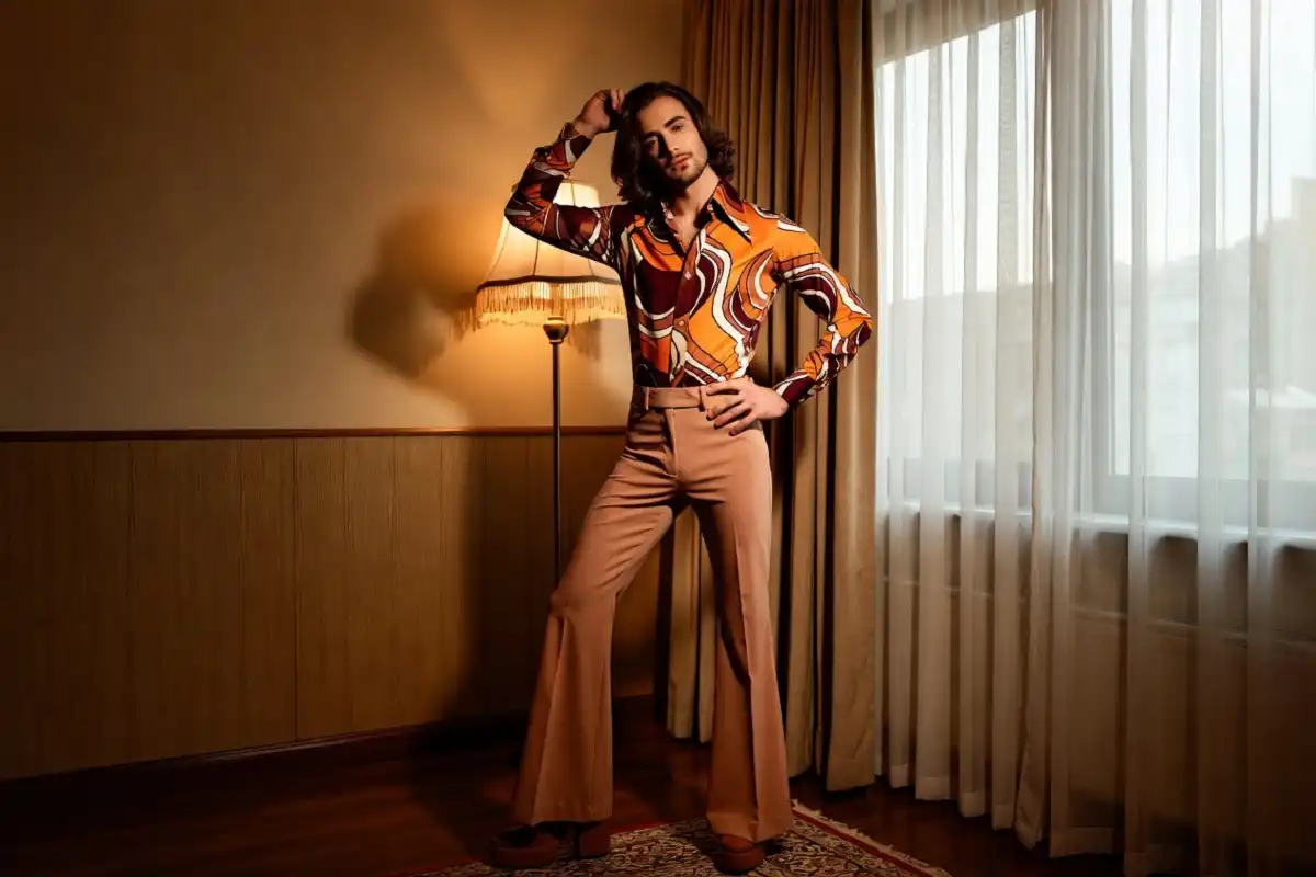 Man in 70s fashion men style with wide collar shirt flared trousers and platform shoes