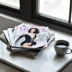 A neat stack of fashion magazines subscriptions on a marble table with coffee