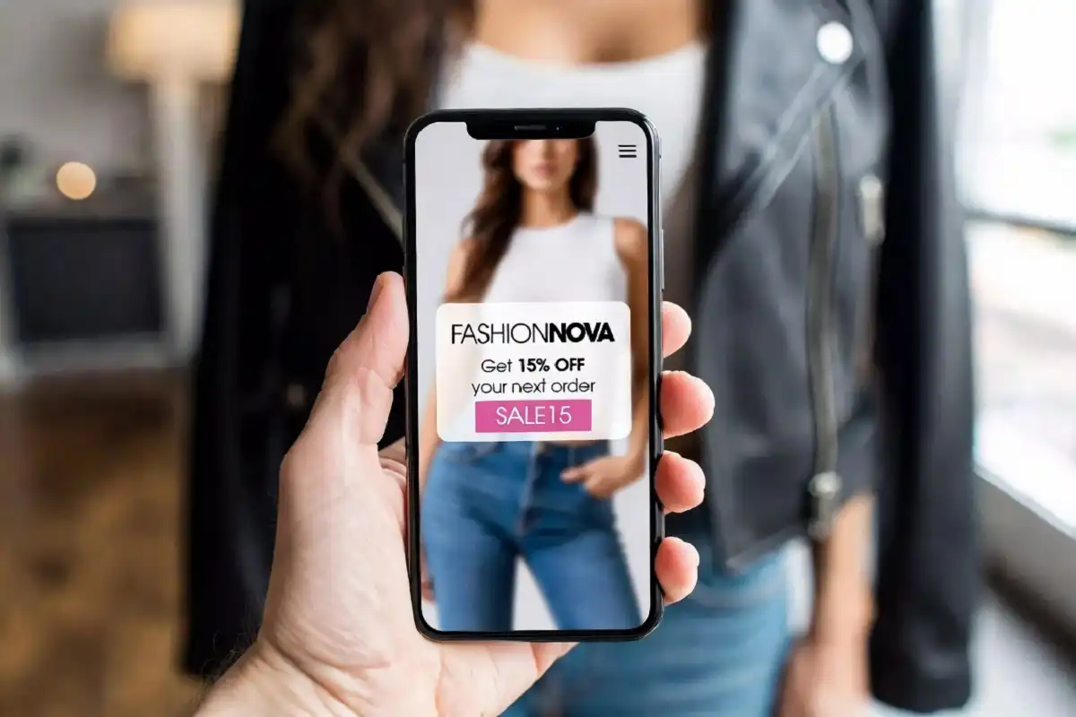 Fashion Nova mobile app open on a phone showing exclusive discount codes and flash sale notification