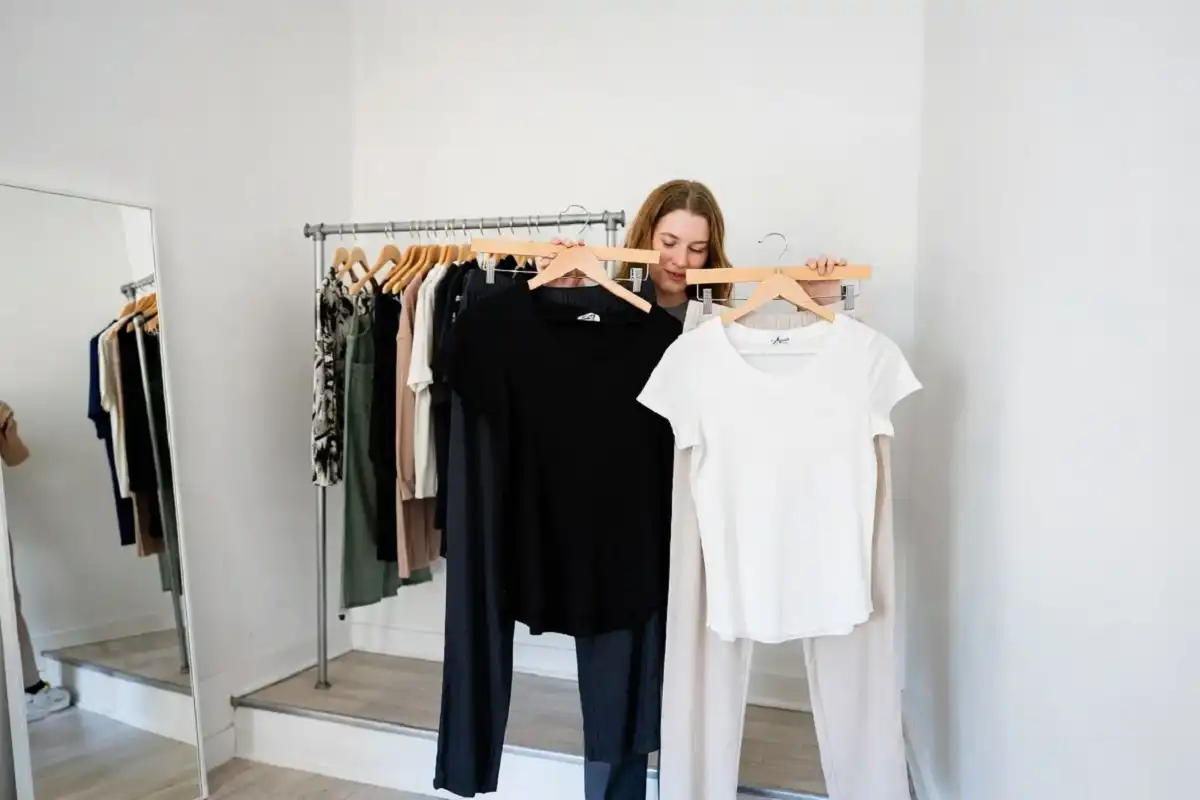 Person in a boutique dressing room comparing two outfit options representing thoughtful style decisions