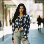 A woman wearing female 90s fashion grunge style with flannel shirt and high-waist jeans