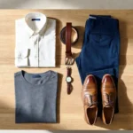Flat lay of a frugal male fashion capsule wardrobe with neutral toned clothing