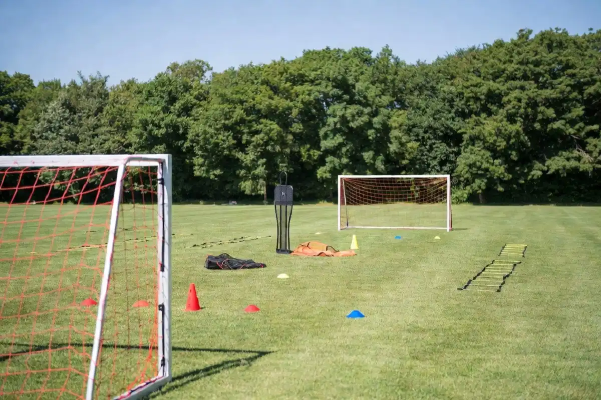 Outdoor sports field organized with gopher sports equipment including goals, cones, and agility ladders on green grass