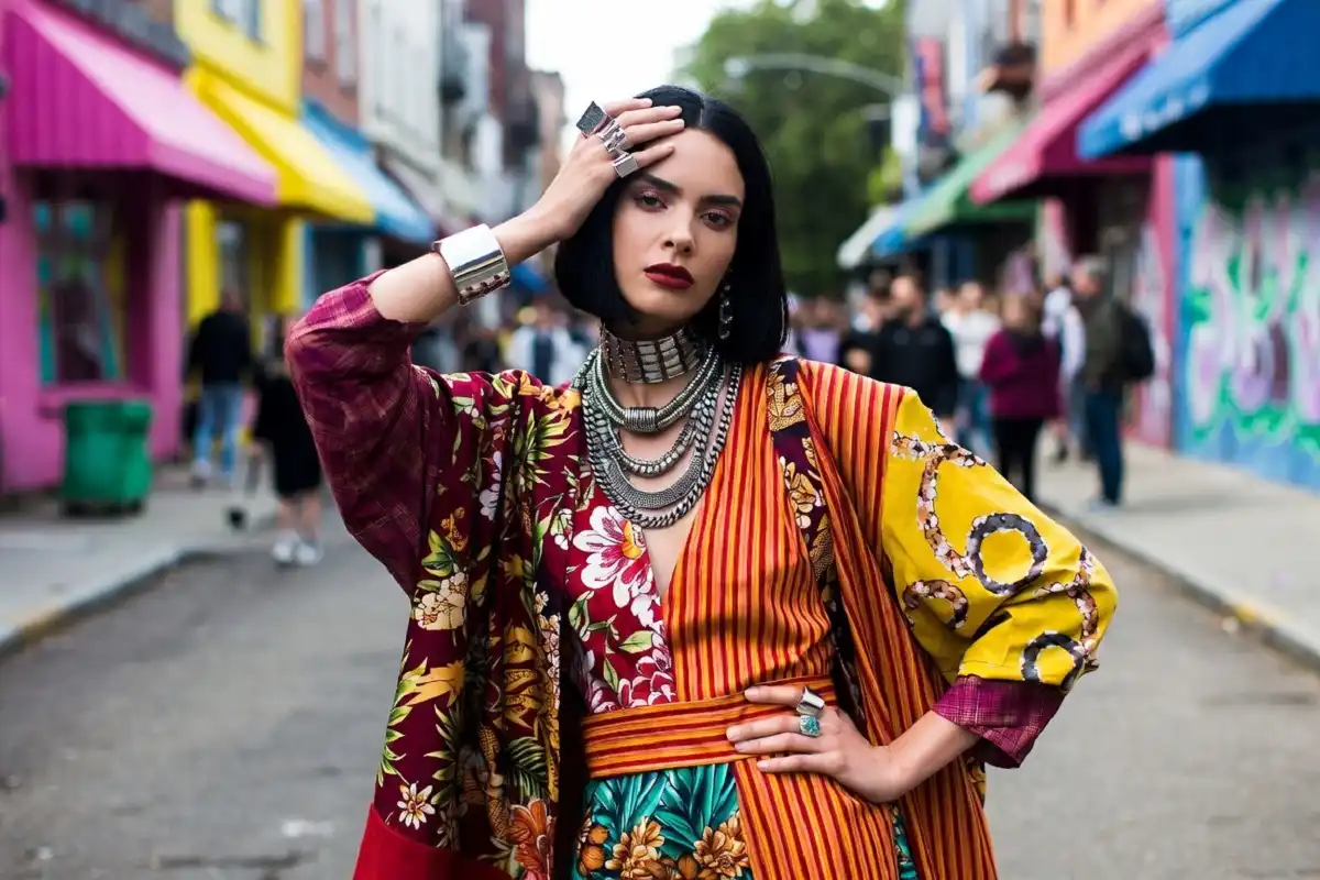 A model wearing bold maximalist print patterns mixing florals and stripes in 2024 fashion style