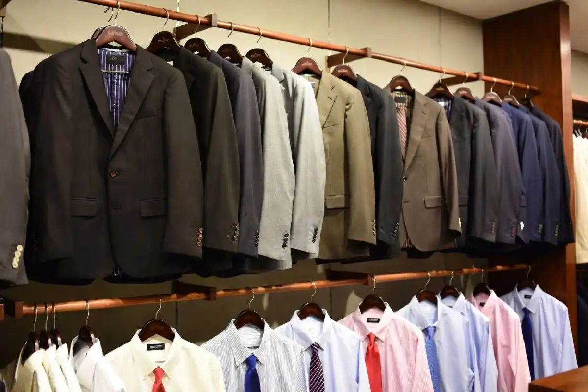 Display of men's suits, sport coats, shirts, and ties on a rack