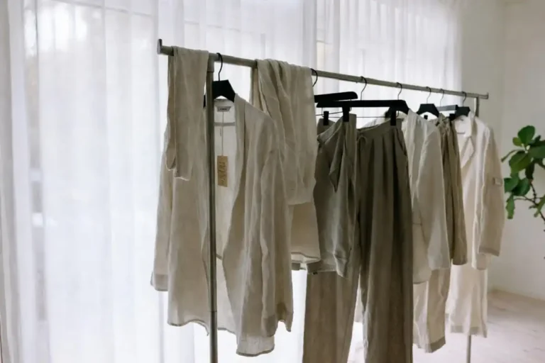 NAKD fashion outfits displayed on a minimal Scandinavian-style clothing rack with neutral tones and sustainable fabric tags