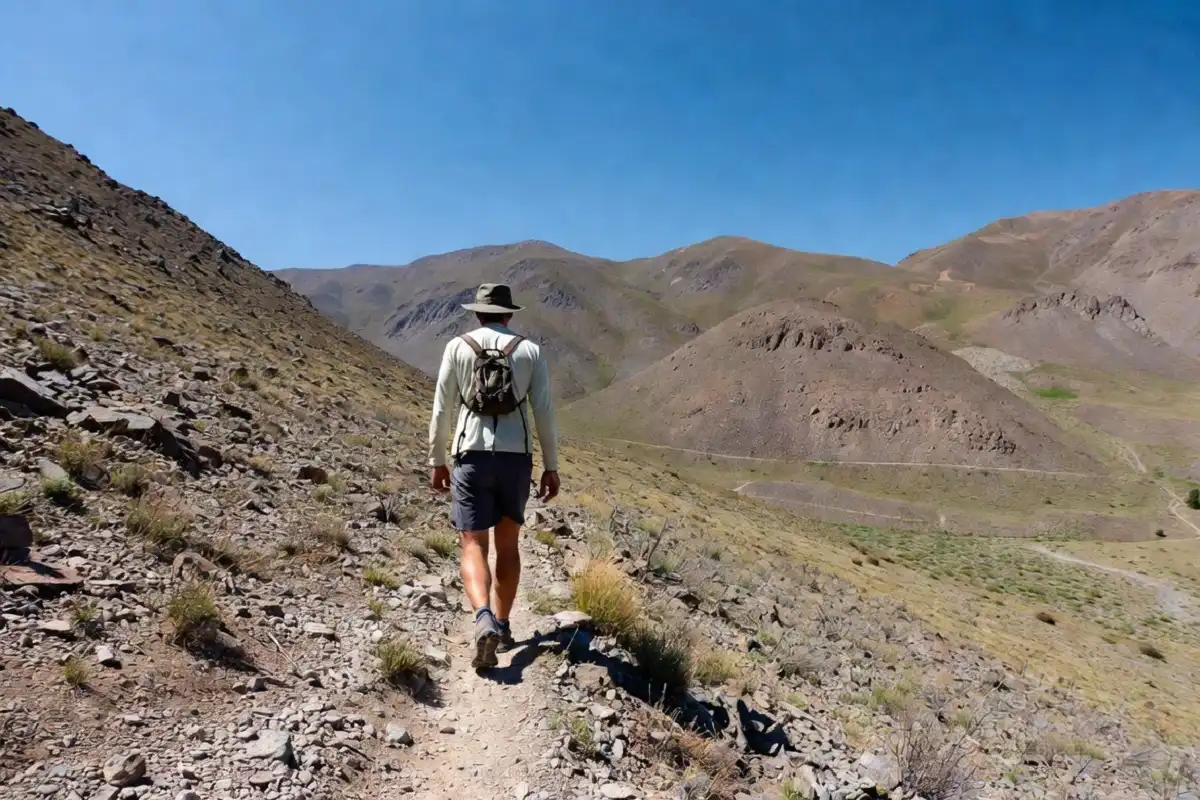 Hiker on a mountain trail using budget hiking essentials