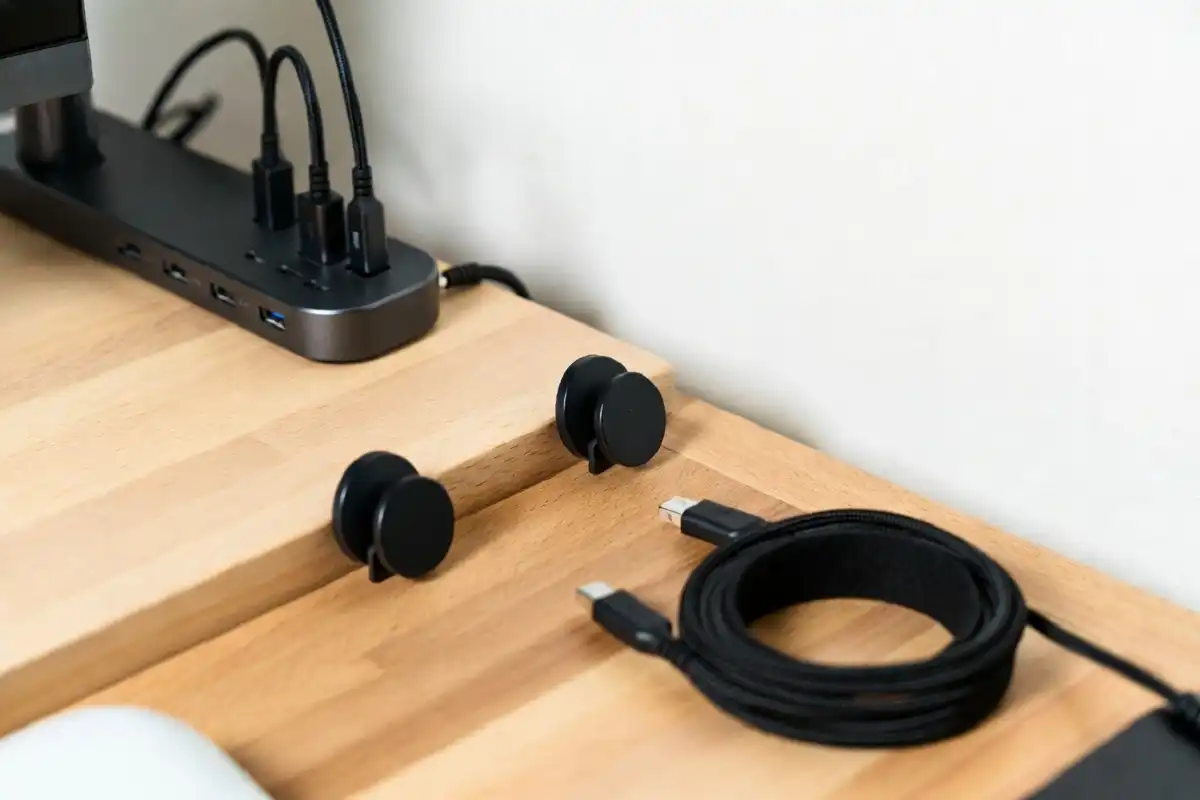 Close-up of cable organizers and a charging dock on a clean wooden desk