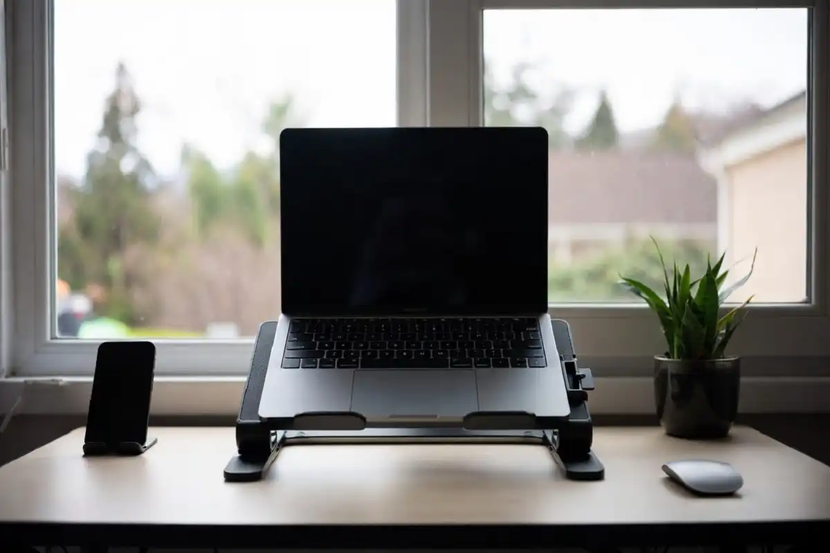 Foldable laptop stand and slim wireless mouse on a compact remote work desk