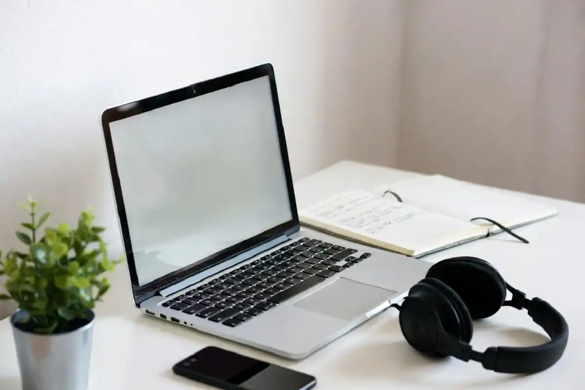 Tidy work desk with notebook, laptop, and small gadgets