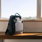 Compact travel backpack sitting on a wooden bench ready for packing