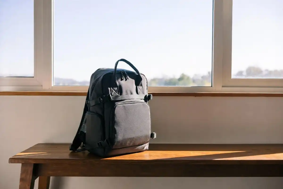 Compact travel backpack sitting on a wooden bench ready for packing